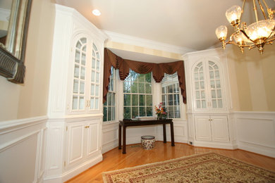 Cette image montre un salon traditionnel de taille moyenne et fermé avec un mur beige, une salle de réception, un sol en bois brun, aucune cheminée et aucun téléviseur.