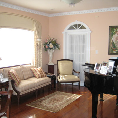 Living room - small traditional open concept medium tone wood floor and brown floor living room idea in New York with a music area, pink walls, no fireplace and no tv