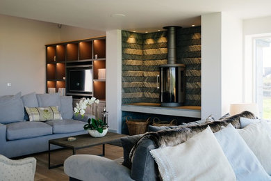 Imagen de salón contemporáneo con paredes grises y estufa de leña