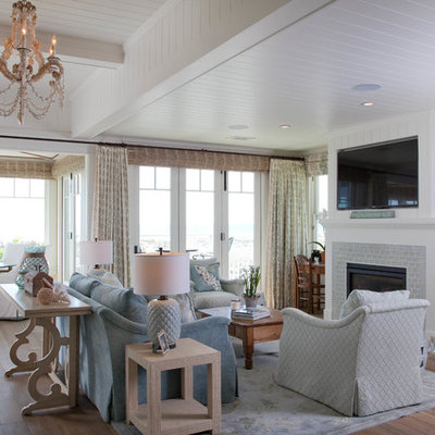 Living room - huge coastal open concept medium tone wood floor living room idea in San Diego with white walls, a standard fireplace, a wall-mounted tv and a brick fireplace