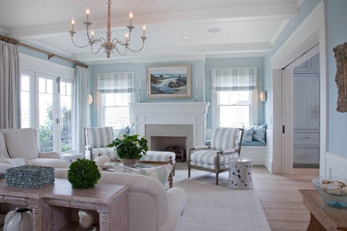 Cette image montre un grand salon marin fermé avec un mur bleu, parquet clair, une cheminée standard, un manteau de cheminée en carrelage, une salle de réception, aucun téléviseur et un sol marron.