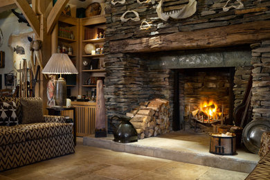 グロスタシャーにあるコンテンポラリースタイルのおしゃれなリビング (薪ストーブ、石材の暖炉まわり、ベージュの床) の写真