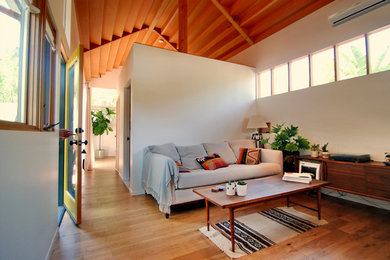 Esempio di un piccolo soggiorno design aperto con pareti bianche e pavimento in legno massello medio