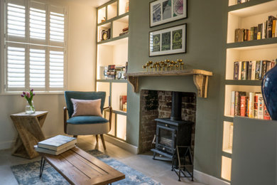 Inspiration for a small scandi enclosed living room in Kent with green walls, porcelain flooring, a wood burning stove, grey floors and a chimney breast.