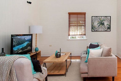 Стильный дизайн: открытая гостиная комната среднего размера в стиле кантри с белыми стенами, паркетным полом среднего тона, отдельно стоящим телевизором и коричневым полом - последний тренд