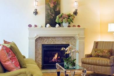 Imagen de salón tradicional renovado de tamaño medio con paredes amarillas, suelo de madera en tonos medios, marco de chimenea de piedra y suelo marrón