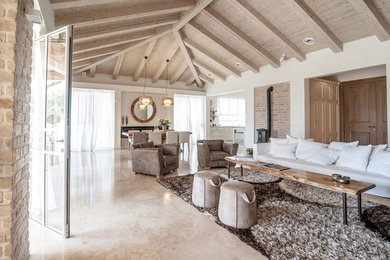 Cette photo montre un salon méditerranéen de taille moyenne et ouvert avec une salle de réception, un sol en calcaire, un poêle à bois et un manteau de cheminée en métal.