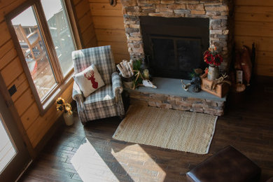 Example of a mountain style dark wood floor and wood wall living room design in Other