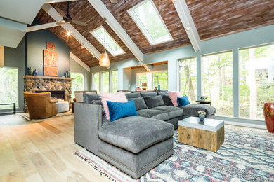 Cette photo montre un salon avec parquet clair, une cheminée standard et un manteau de cheminée en pierre.