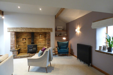 Modelo de salón para visitas cerrado contemporáneo grande con paredes púrpuras, moqueta, estufa de leña, marco de chimenea de ladrillo, televisor independiente y suelo gris