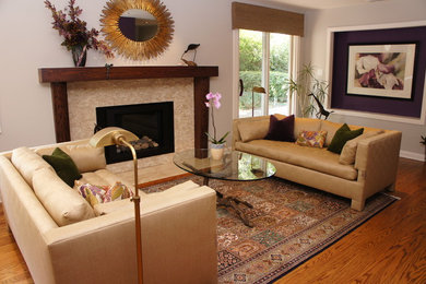 Example of a mid-sized classic medium tone wood floor and brown floor living room design in San Francisco with gray walls, a standard fireplace, a stone fireplace and no tv
