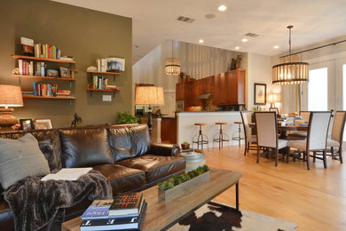 Offenes Industrial Wohnzimmer mit grüner Wandfarbe und hellem Holzboden in Austin
