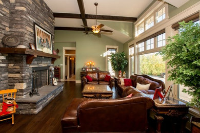 Example of a mid-sized arts and crafts open concept dark wood floor living room design in Calgary with a two-sided fireplace and a stone fireplace