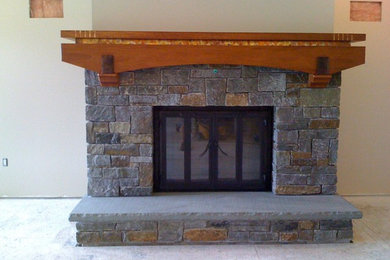 Cette image montre un salon craftsman de taille moyenne et fermé avec un mur beige, moquette, une cheminée standard et un manteau de cheminée en pierre.