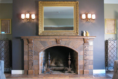 ポートランドにある広いトラディショナルスタイルのおしゃれなリビング (タイルの暖炉まわり、グレーの壁、淡色無垢フローリング、標準型暖炉、茶色い床) の写真