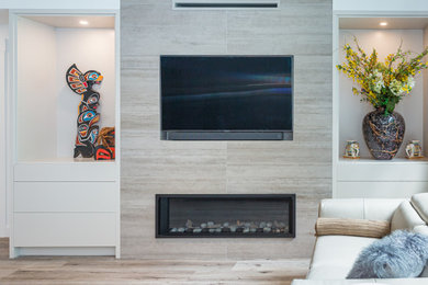 他の地域にある高級な小さなコンテンポラリースタイルのおしゃれなLDK (白い壁、ラミネートの床、標準型暖炉、タイルの暖炉まわり、埋込式メディアウォール、茶色い床) の写真
