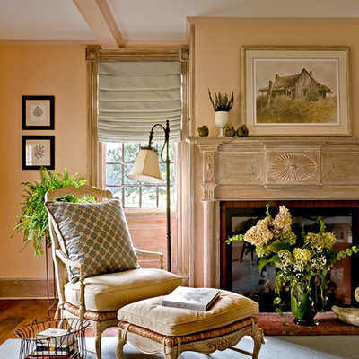 Example of a classic medium tone wood floor living room design in New York with a standard fireplace