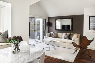 Стильный дизайн: маленькая открытая гостиная комната в современном стиле с белыми стенами, темным паркетным полом и телевизором на стене для на участке и в саду - последний тренд