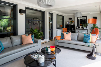 Medium sized contemporary enclosed living room in London with carpet, a plastered fireplace surround and grey floors.