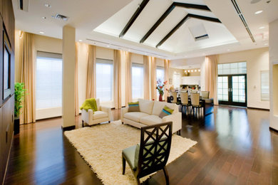 Cette image montre un grand salon minimaliste fermé avec un bar de salon, un mur beige, parquet foncé, aucune cheminée, un téléviseur encastré et un sol marron.