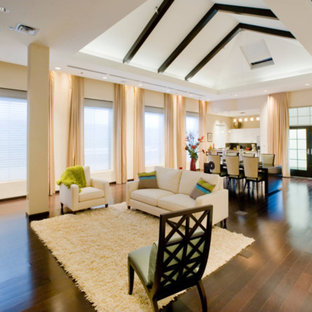 Example of a large minimalist enclosed dark wood floor and brown floor living room design in San Diego with a bar, beige walls, no fireplace and a media wall