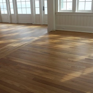 Idee per un grande soggiorno american style aperto con pavimento in legno massello medio, pareti rosa, nessun camino, nessuna TV e pavimento marrone