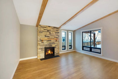 Mid-sized elegant enclosed light wood floor and beige floor living room photo in Denver with gray walls, a standard fireplace, a stone fireplace and no tv
