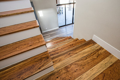 Fernseherloses, Offenes Modernes Wohnzimmer ohne Kamin mit grauer Wandfarbe und braunem Holzboden in Austin