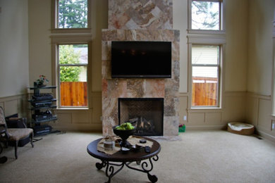 Imagen de salón tradicional renovado grande con paredes beige, moqueta, todas las chimeneas, marco de chimenea de piedra y televisor colgado en la pared