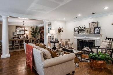 Example of a mid-sized eclectic medium tone wood floor and brown floor living room design in Dallas with beige walls and a wood fireplace surround