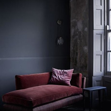 Dark and cosy corner with red velvet chaise