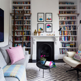 Eklektisk inredning av ett vardagsrum, med ett bibliotek, vita väggar och en standard öppen spis