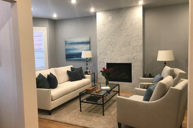 Example of a mid-sized trendy formal and enclosed laminate floor and brown floor living room design in San Francisco with gray walls, a standard fireplace, a tile fireplace and no tv