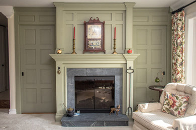 Klassisches Wohnzimmer mit Kaminumrandung aus Stein und verstecktem TV in New York