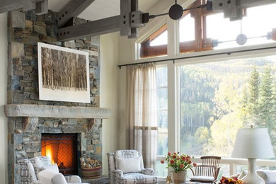 Example of a mountain style medium tone wood floor living room design in Seattle with white walls, a standard fireplace and a stone fireplace