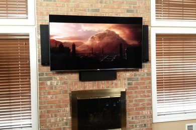 Imagen de salón moderno de tamaño medio con televisor colgado en la pared