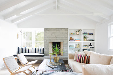 Inspiration for a coastal living room remodel in San Diego with a concrete fireplace, white walls, a standard fireplace and no tv