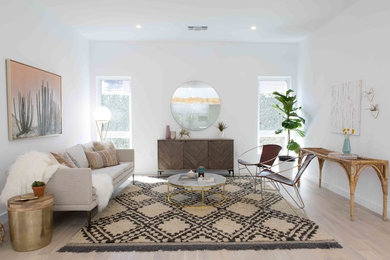 Contemporary living room in Los Angeles with white walls, light hardwood flooring and beige floors.