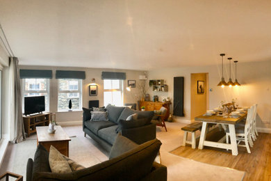 Large scandi open plan living room in Other with a reading nook, grey walls, carpet, a freestanding tv and grey floors.