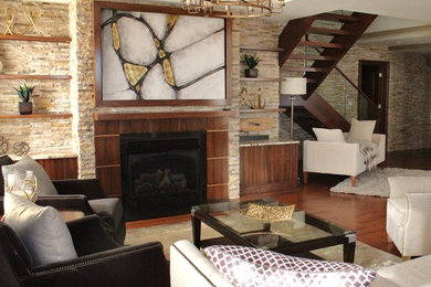 Inspiration pour un grand salon traditionnel ouvert avec un mur beige, un sol en bois brun, une cheminée standard et un manteau de cheminée en pierre.