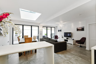 Contemporary living room in London with concrete flooring and a wall mounted tv.