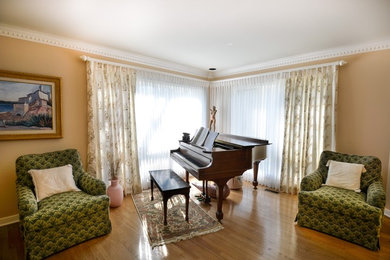 На фото: большая открытая гостиная комната в стиле неоклассика (современная классика) с бежевыми стенами, паркетным полом среднего тона и музыкальной комнатой без камина