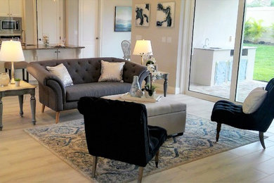 Immagine di un grande soggiorno chic aperto con sala formale, pareti grigie, pavimento in gres porcellanato, nessun camino e TV autoportante