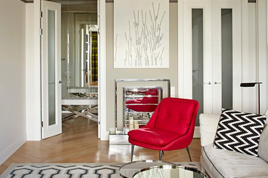Modelo de salón para visitas abierto actual de tamaño medio con televisor colgado en la pared, paredes blancas y suelo de madera clara