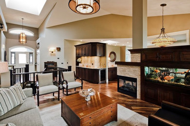 Example of a large classic open concept medium tone wood floor and brown floor living room design in Calgary with brown walls, a two-sided fireplace and a brick fireplace