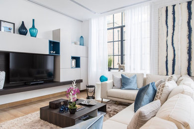 Photo of a contemporary living room in London with white walls, a wall mounted tv and brown floors.