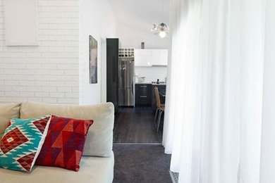 Идея дизайна: парадная, открытая гостиная комната среднего размера в стиле ретро с белыми стенами, паркетным полом среднего тона и фасадом камина из штукатурки без телевизора