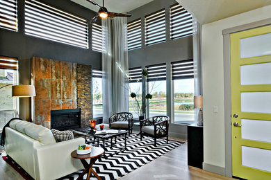 Großes Modernes Wohnzimmer mit grauer Wandfarbe, braunem Holzboden, Kamin und Kaminumrandung aus Metall in Raleigh