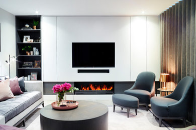 Mid-sized trendy formal and enclosed medium tone wood floor living room photo in Surrey with gray walls, a ribbon fireplace, a wood fireplace surround and a media wall