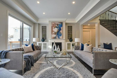 Example of a large transitional open concept and formal brown floor and medium tone wood floor living room design in Toronto with gray walls, a standard fireplace, a wood fireplace surround and no tv